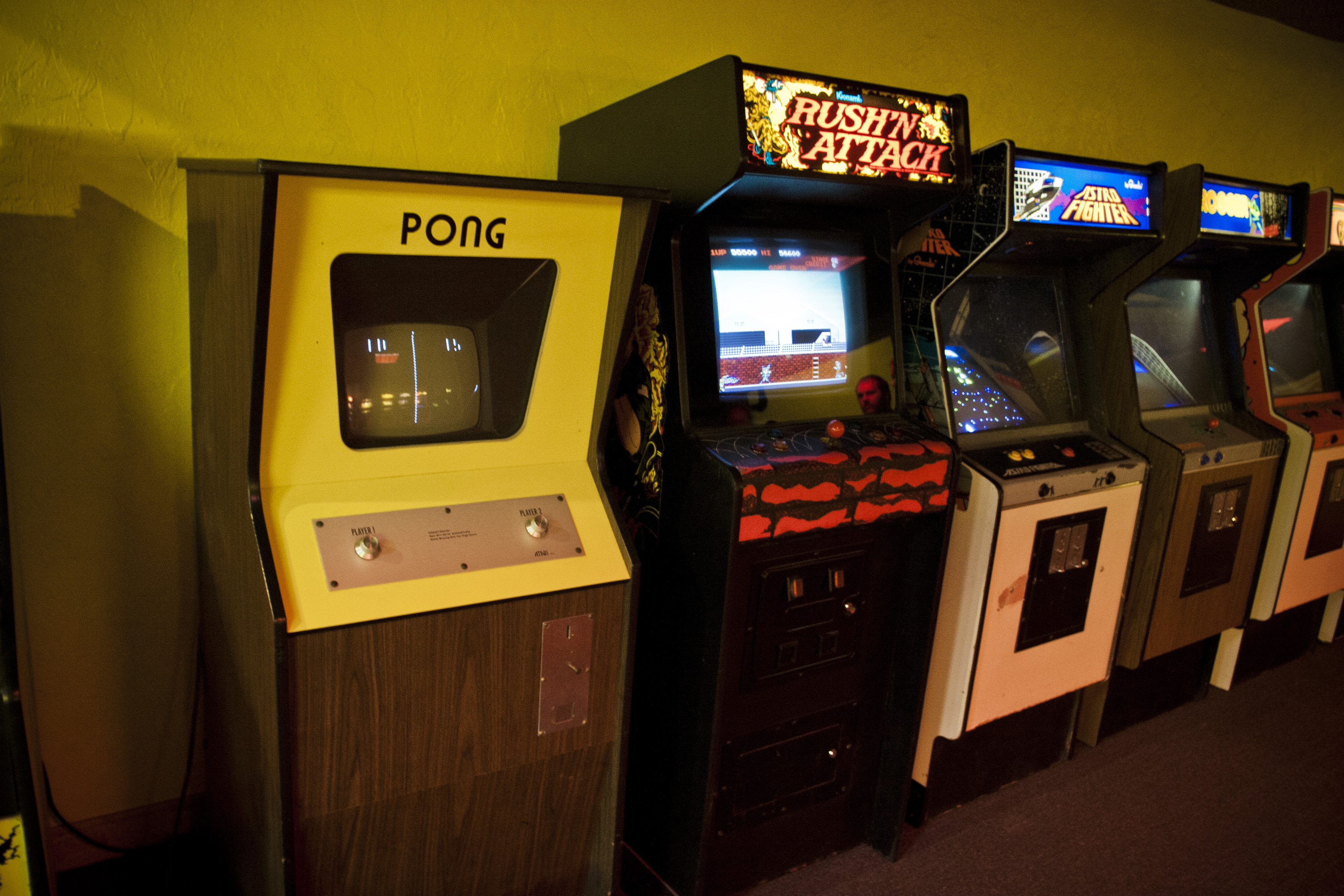 La imagen muestra juegos de arcade en un salón de máquinas recreativas